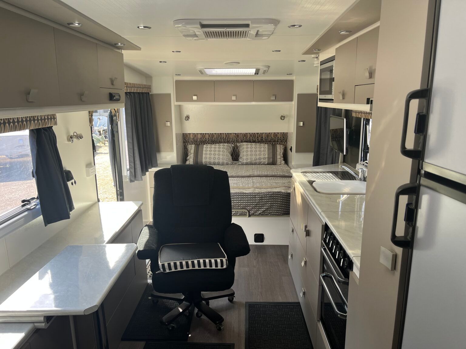 The Inside Of A Camper With A Chair And A Bed — Perkins Caravans in Ballina, NSW