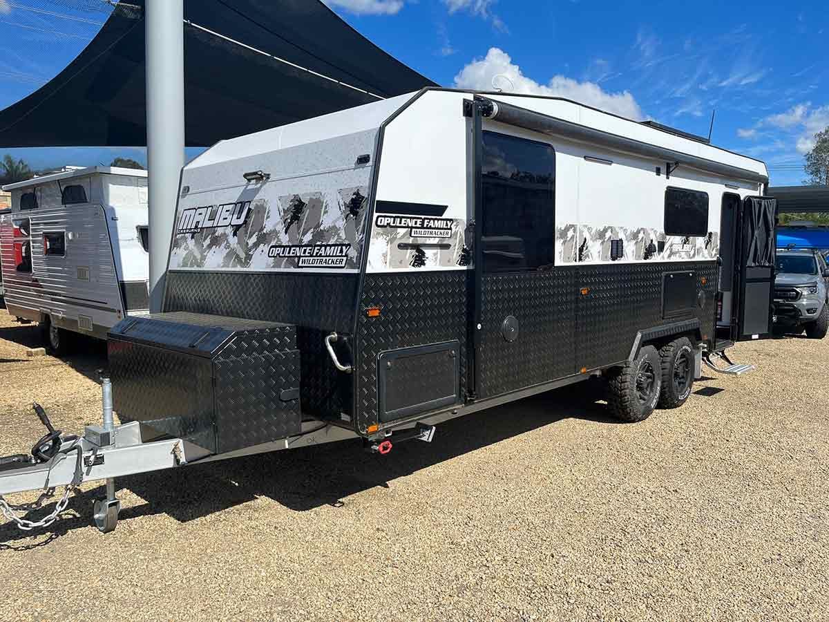 A Black And White Trailer Is Parked In A Gravel Lot — Perkins Caravans in Byron Bay, NSW