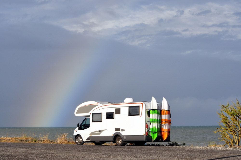 A RV Is Parked On The Side Of The Road Next To The Ocean — Perkins Caravans in Yamba, NSW