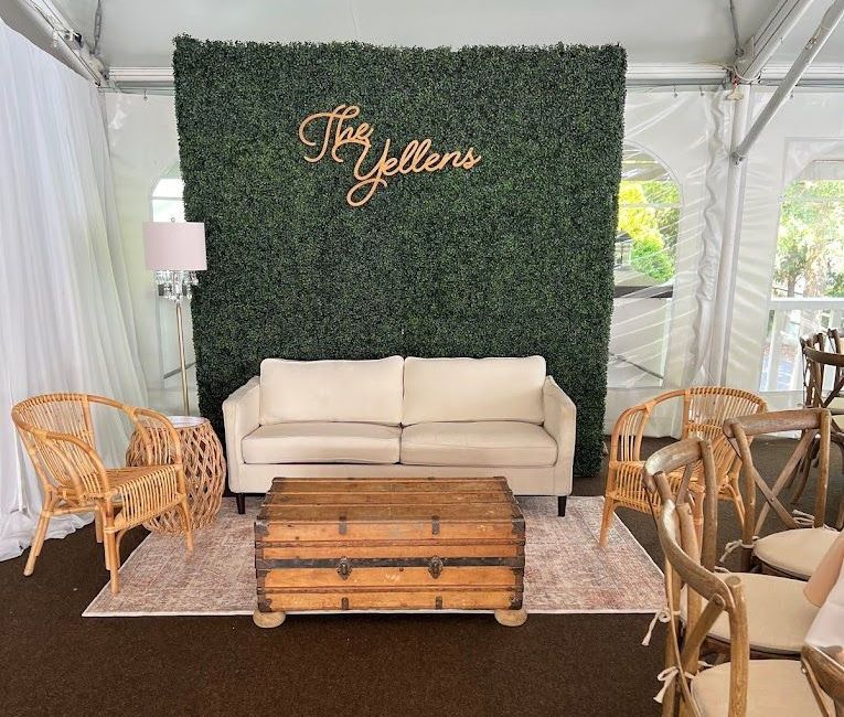 a living room with a couch , table , chairs and a green wall .