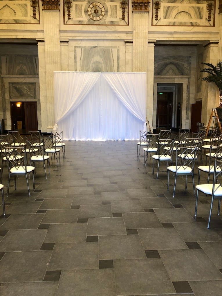 a large room with rows of chairs and a white curtain .