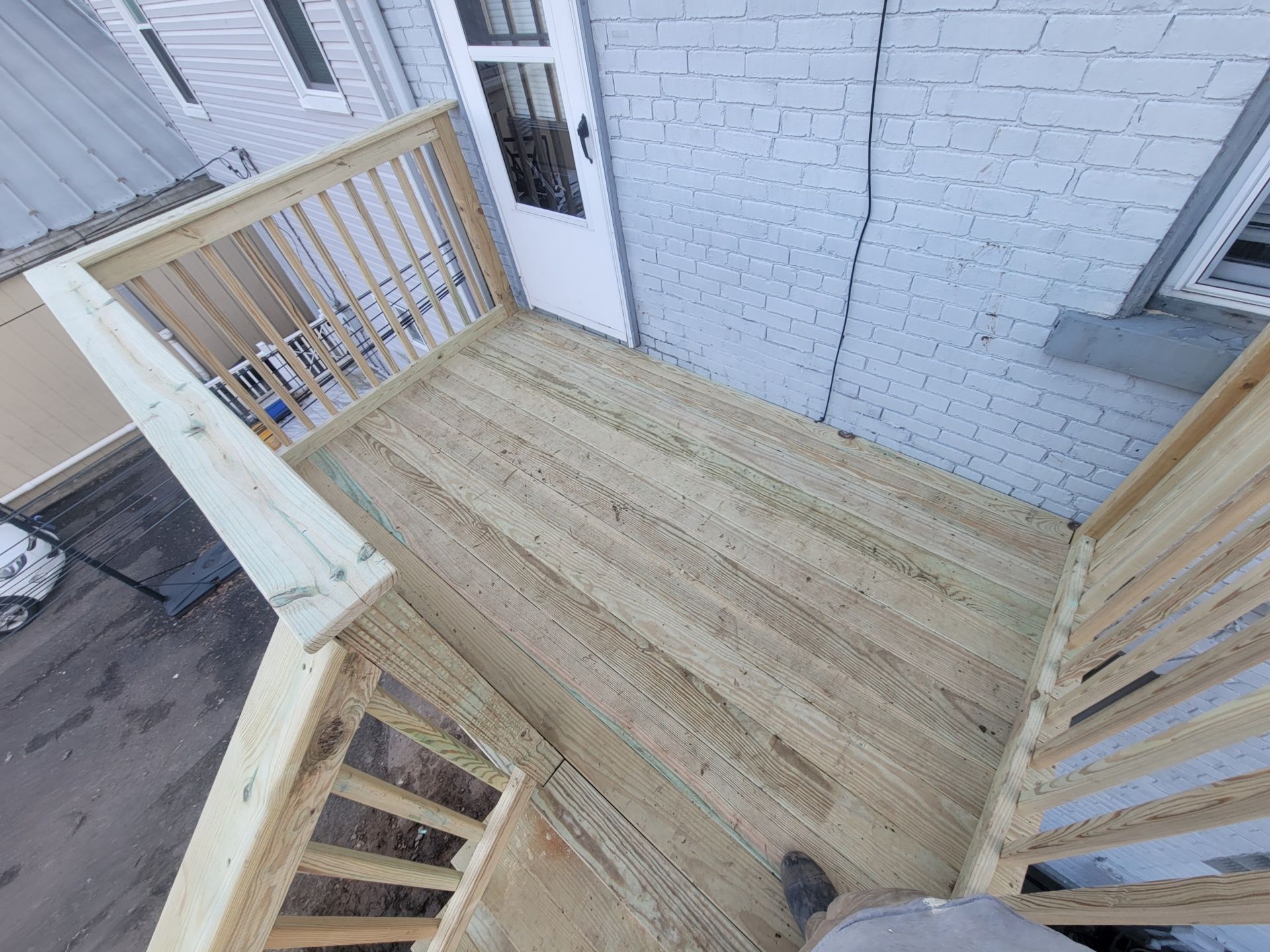 A wooden deck with stairs leading up to a door