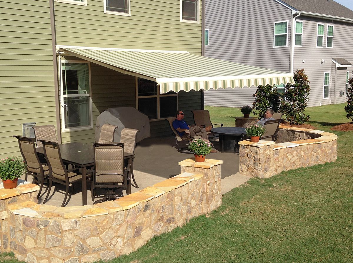 a man sits under an awning on a patio