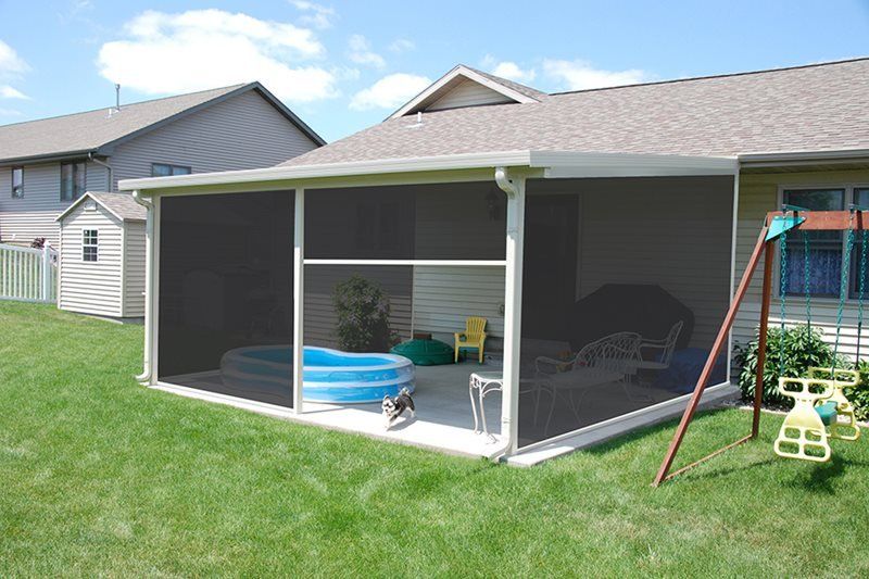 A screened in porch with a pool and a swing set