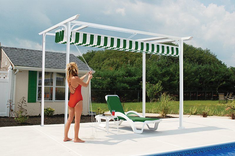 A woman in a red bathing suit is standing under a canopy over a swimming pool