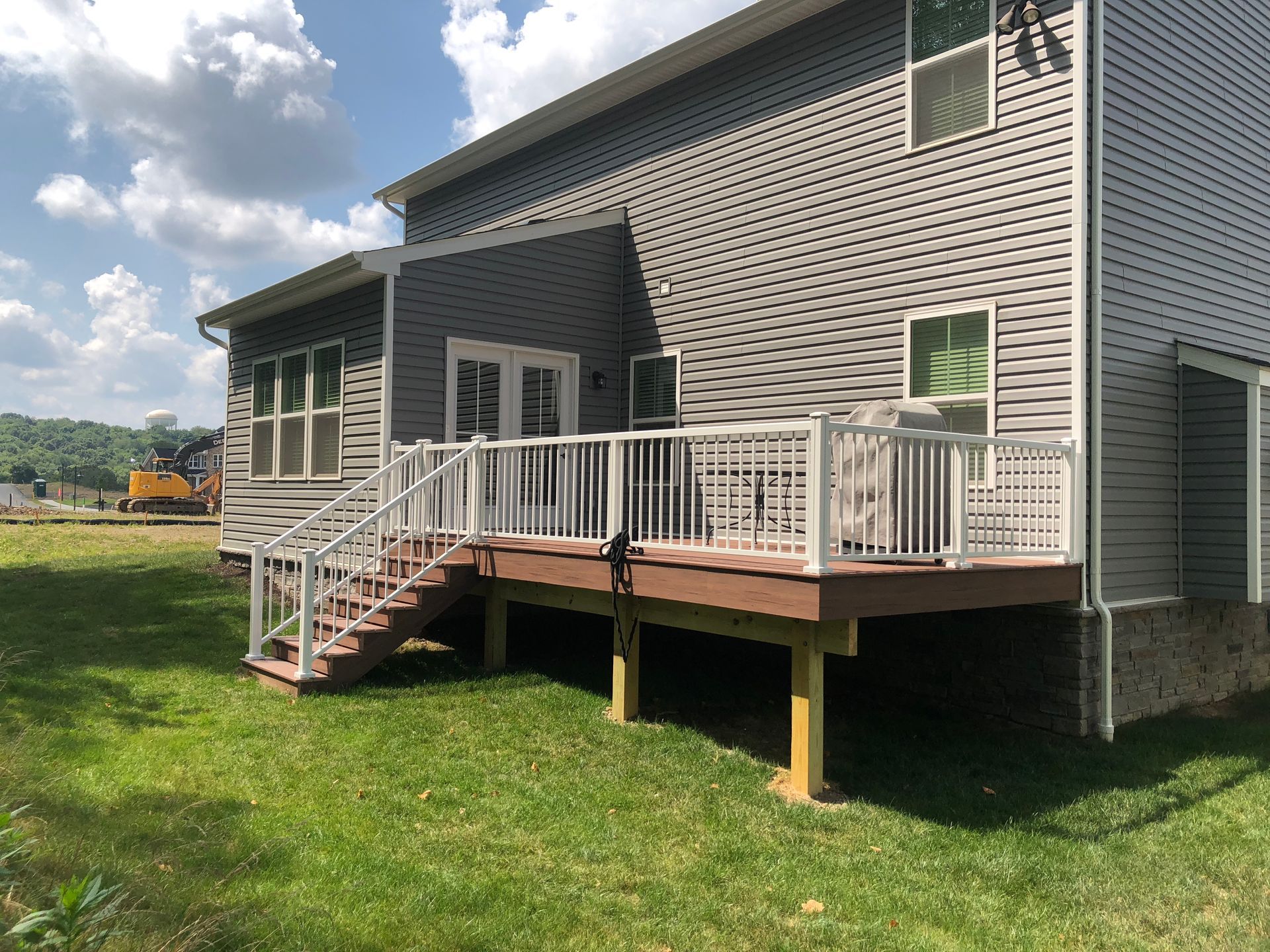 The back of a house with a large deck and stairs