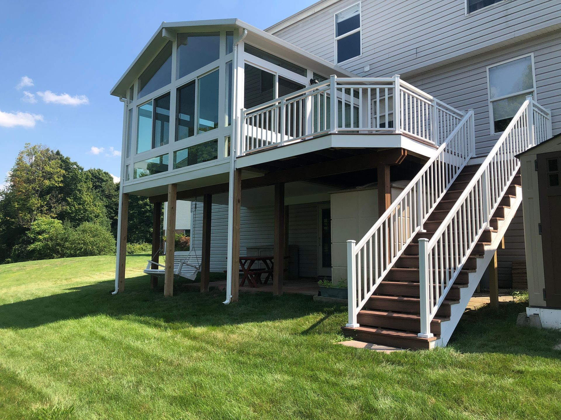 A white house with a screened in porch and stairs