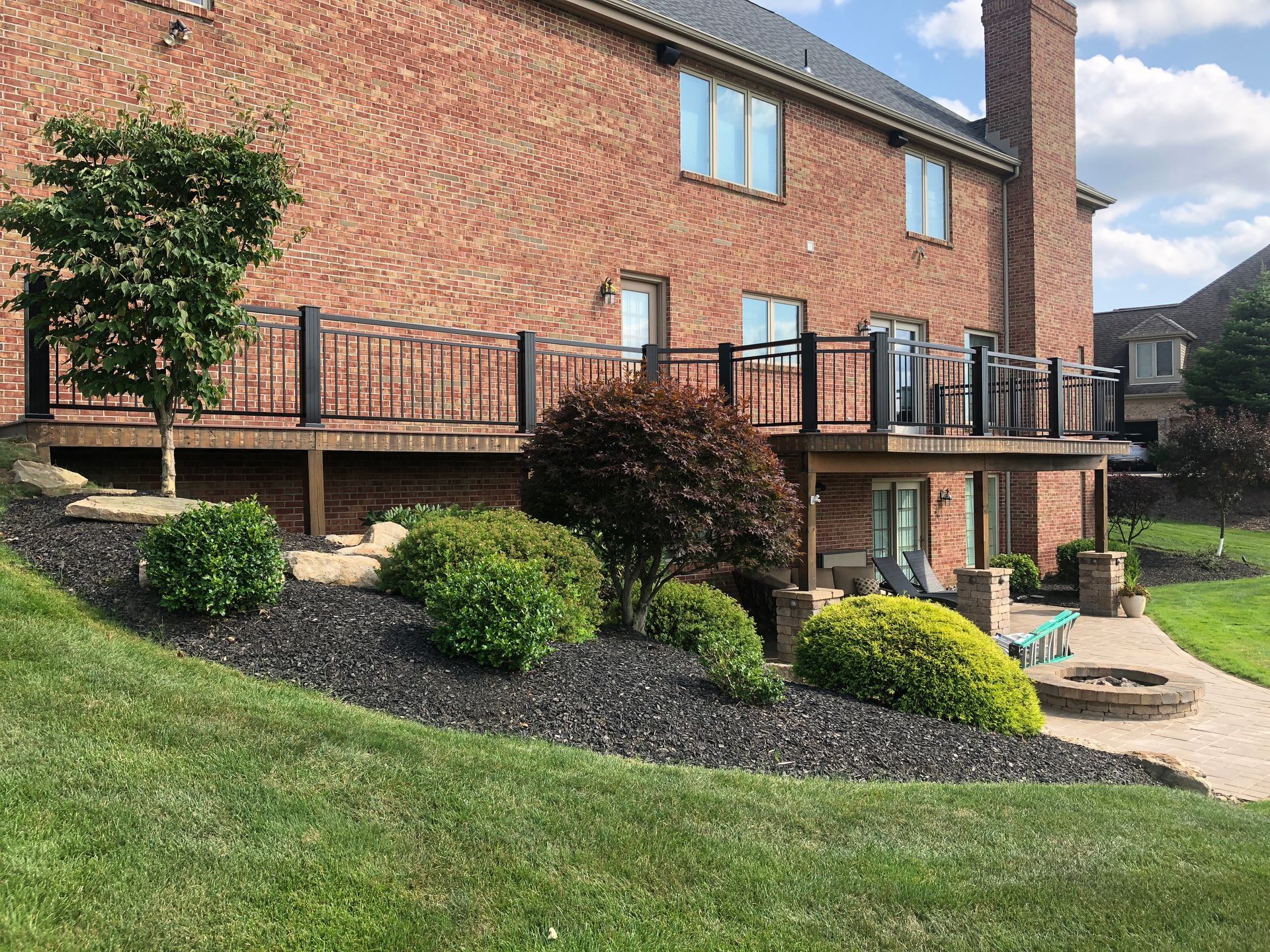 A large brick house with a large deck in front of it