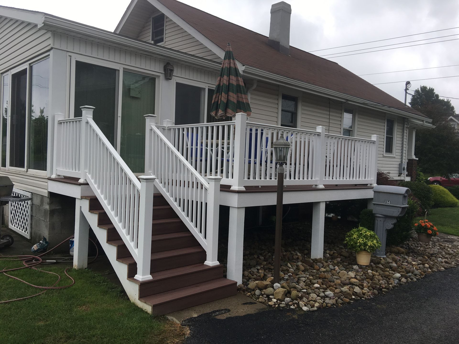 A white house with a white deck and stairs