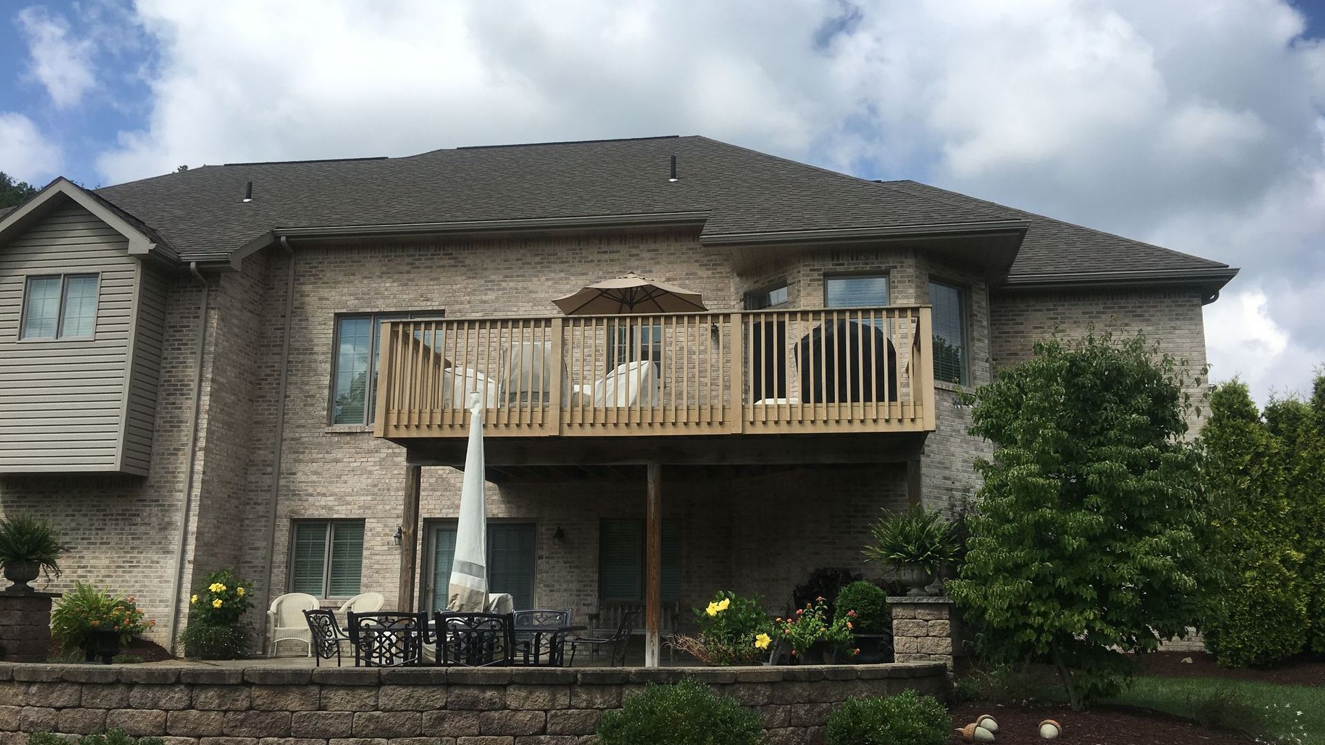 A large brick house with a large wooden deck