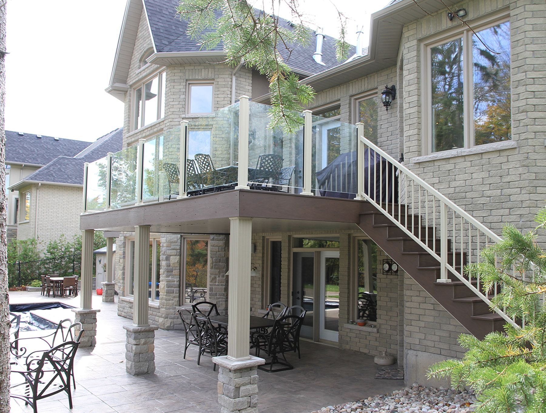 A house with a large deck and stairs leading up to it by Premier Decks & Awnings
