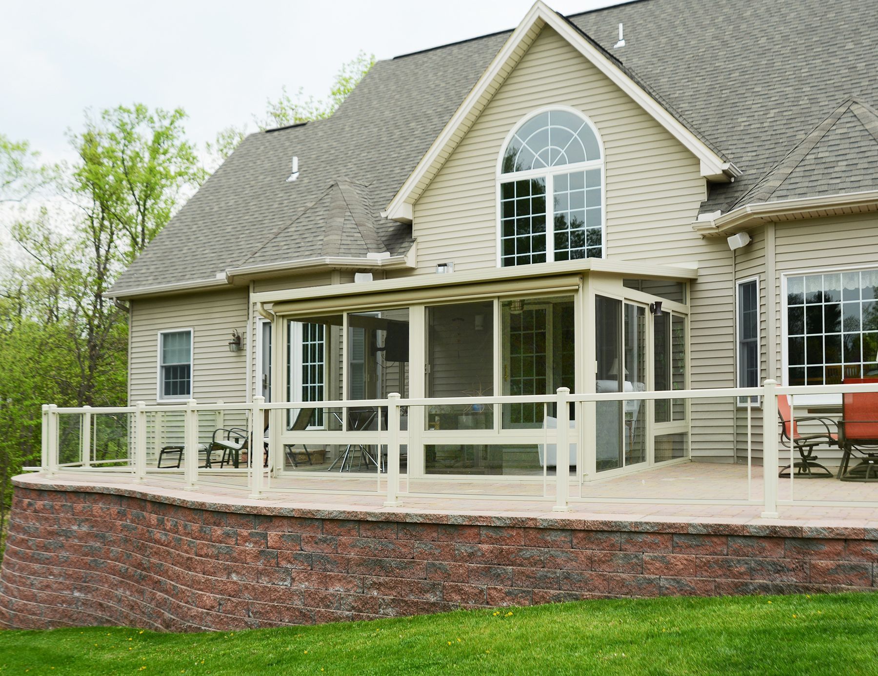 A large house with a large screened in porch by Premier Decks & Awnings