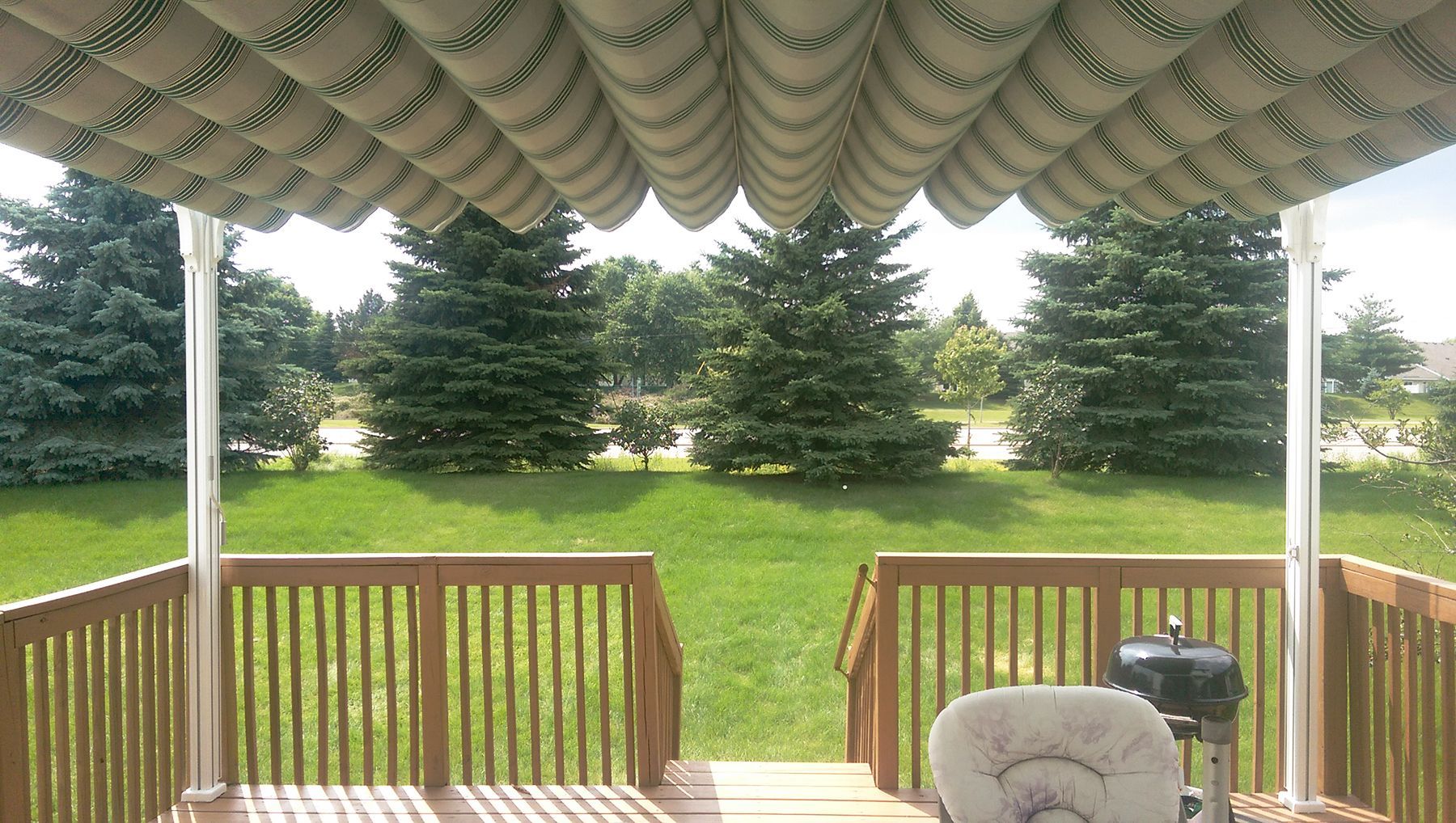 A deck with a table and chairs under a canopy