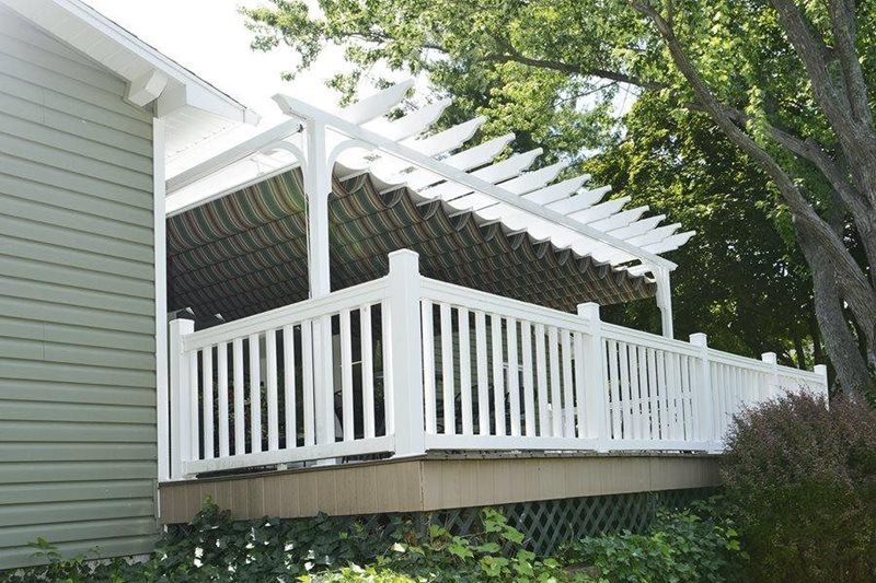 A white deck with a pergola on top of it