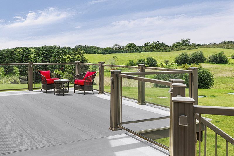 A deck with chairs and a table with a view of a field