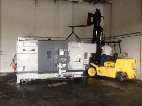 Man Lifting Equipment with Forklift - Machine Movers in Tampa, FL