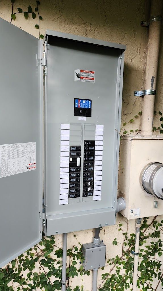 A large electrical box is sitting on the side of a building.