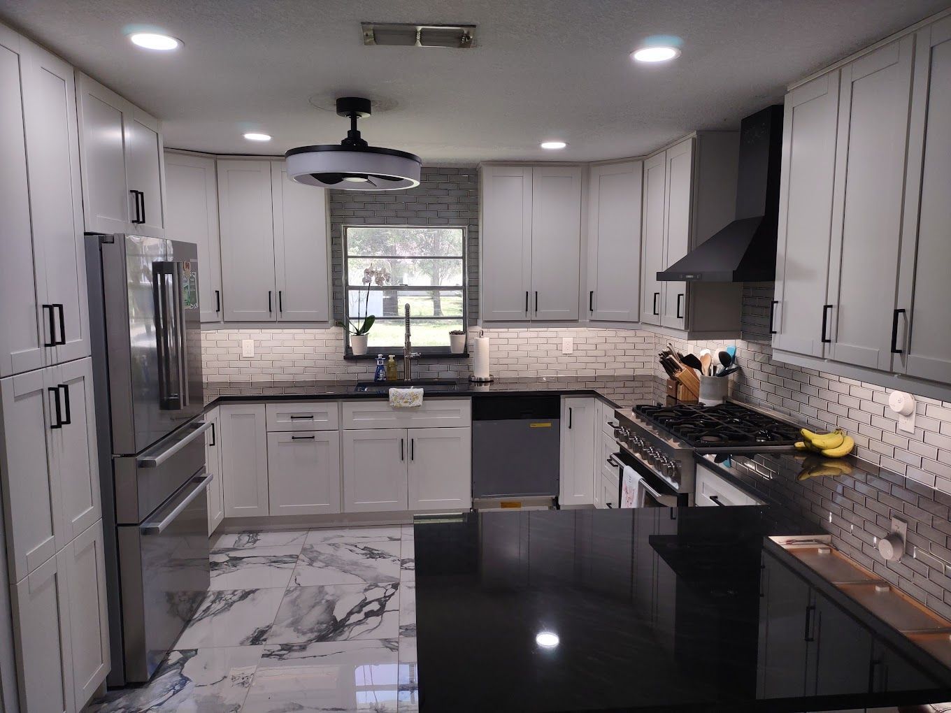 A kitchen with white cabinets and stainless steel appliances