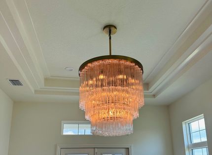 A man is using a multimeter to test an electrical box.