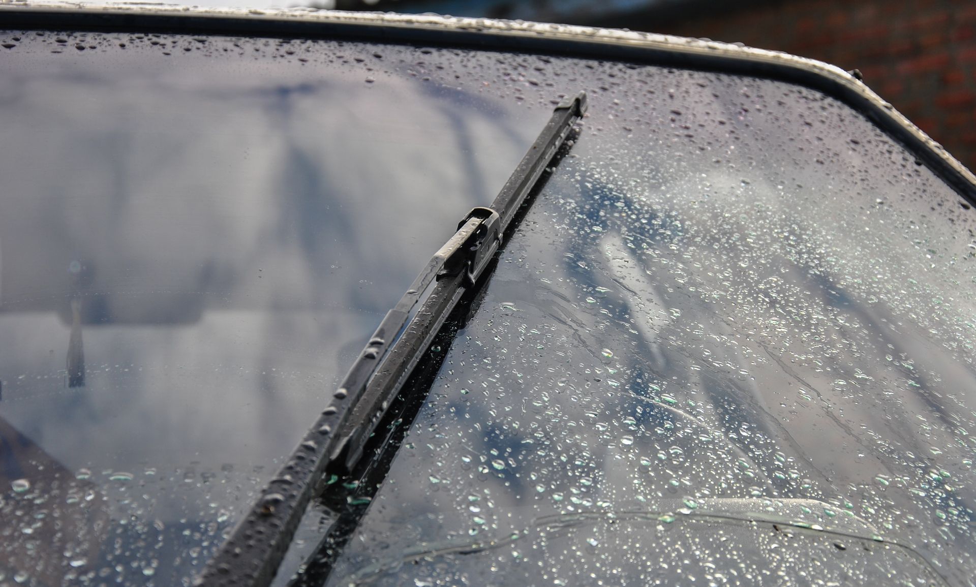 A close up of a car windshield with a wiper on it.