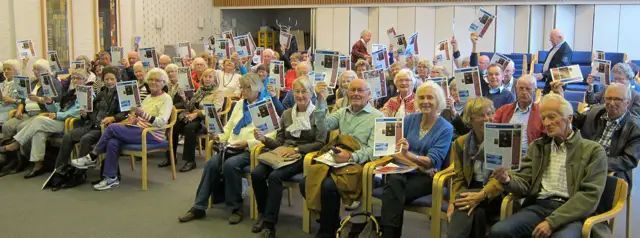 A large group of seniors are learning about Medicare together.