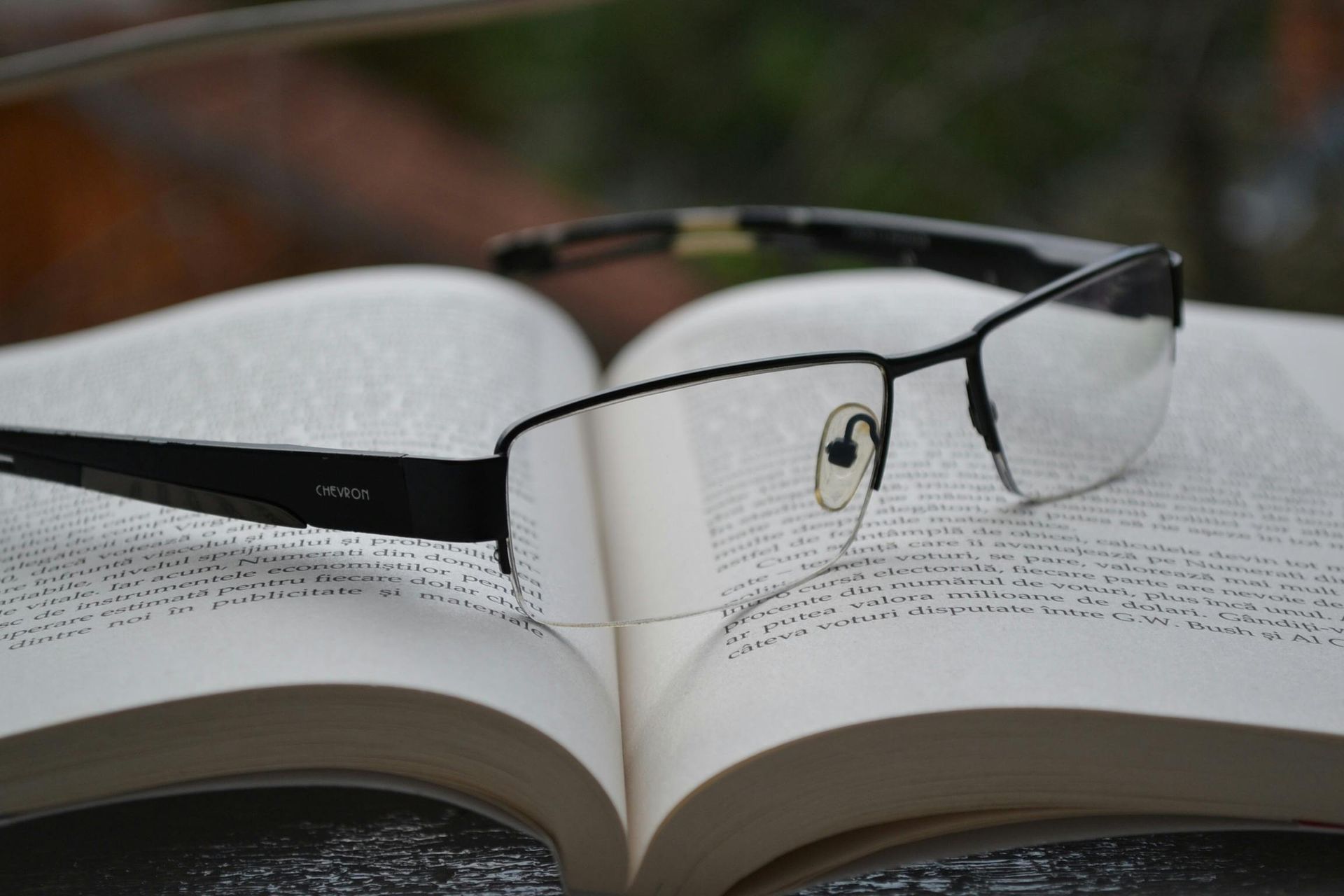 A pair of glasses laying on top of an open book