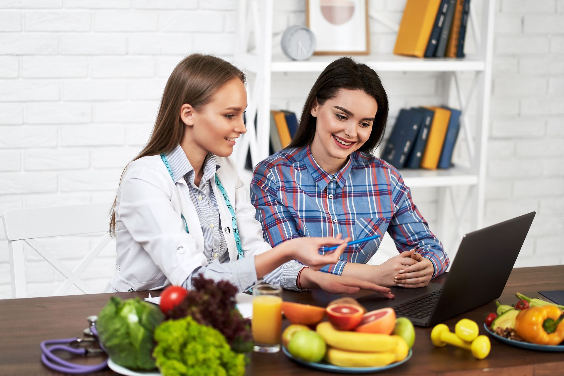 A doctor and a patient are looking at a laptop computer.