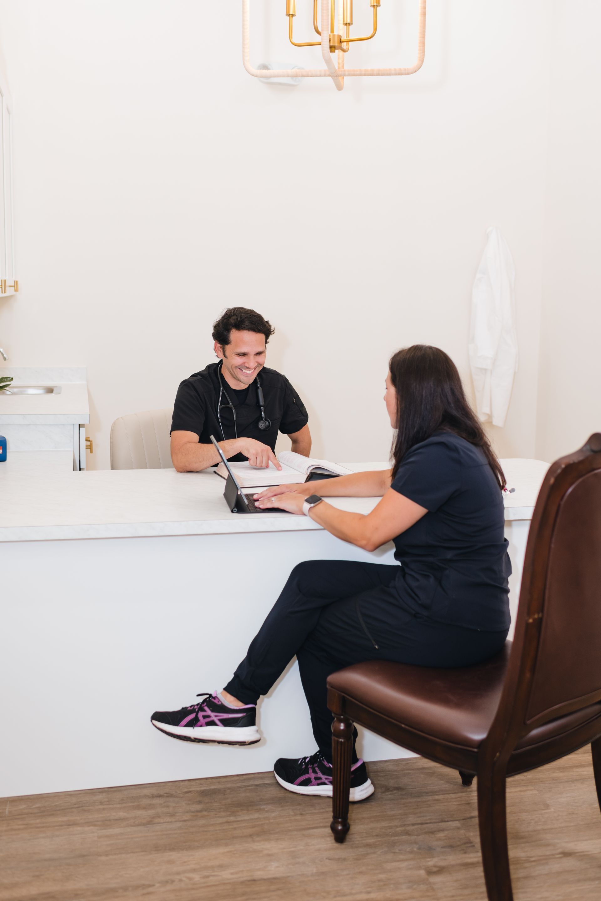A man and a woman are sitting at a counter talking to each other.