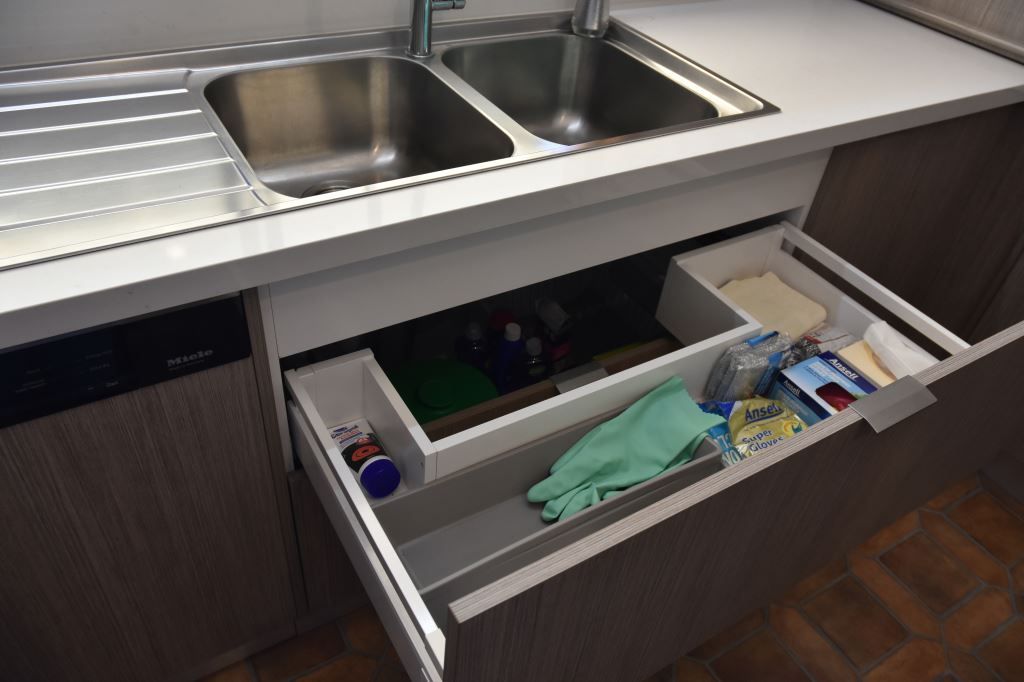 A Kitchen Sink With a Drawer Underneath It Filled With Cleaning Supplies — Stephen Veigel Kitchens In Gosford, NSW