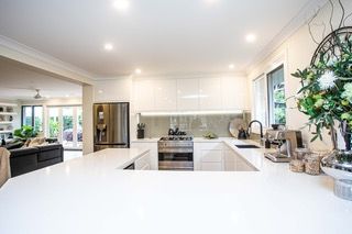 Modern kitchen with white countertops, stainless steel appliances, and a U-shaped island - Stephen Veigel Kitchens In Gosford, NSW