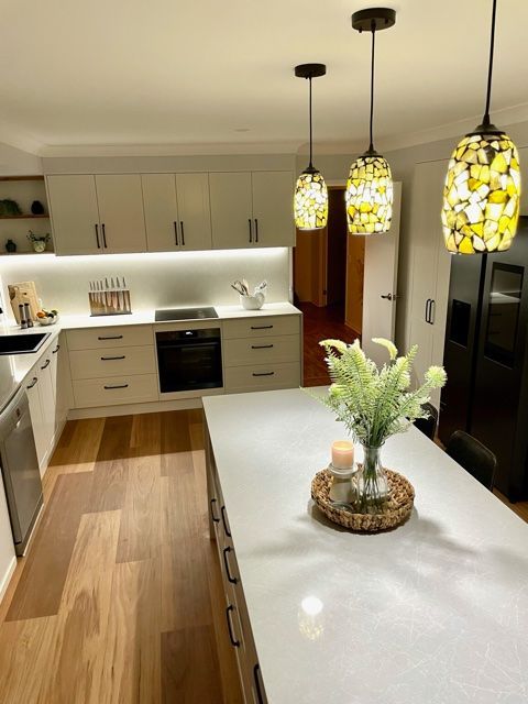 A Kitchen With a Large Island With a Vase of Flowers on It — Stephen Veigel Kitchens In Gosford, NSW