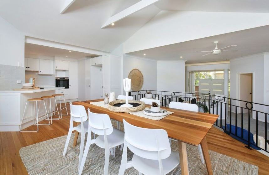 A Dining Room With a Wooden Table and White Chairs — Stephen Veigel Kitchens In Gosford, NSW