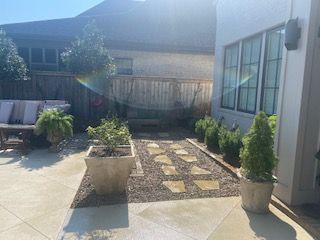 A Patio With Potted Plants and a Bench in the Backyard of a House