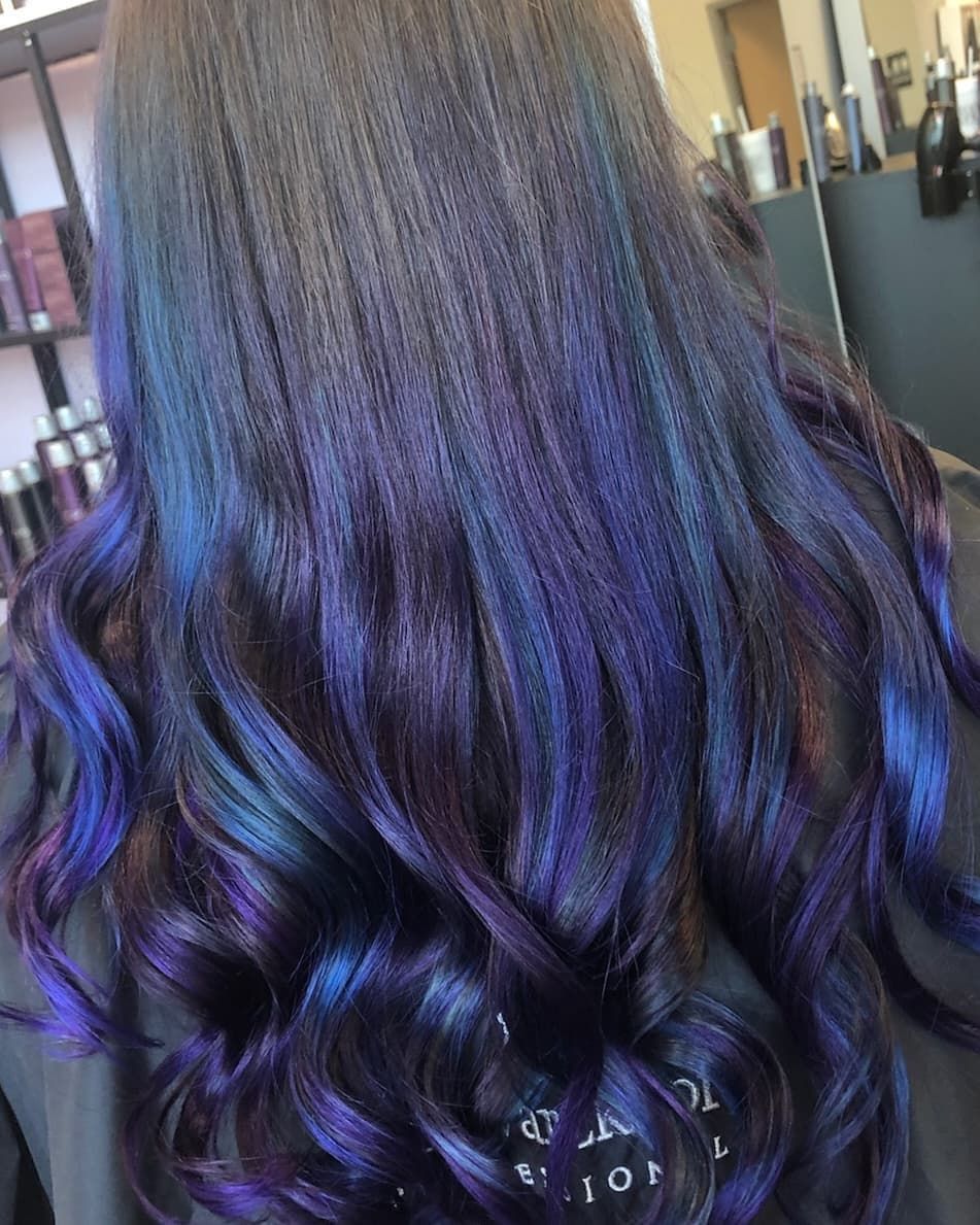 Dark hair with iridescent purple and blue highlights in soft waves.