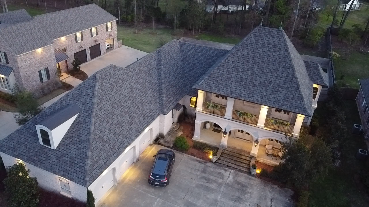An aerial view of a large house with a car parked in front of it.