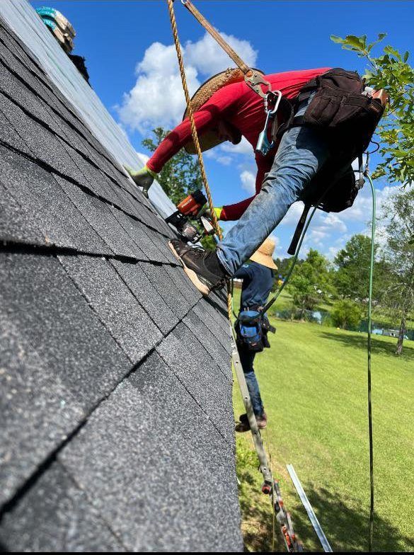 A man is climbing up the side of a roof.