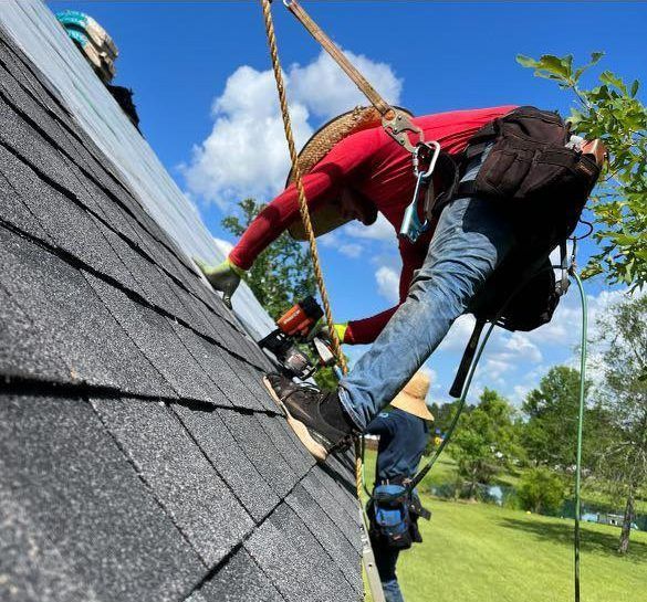 A man in a red shirt is working on a roof
