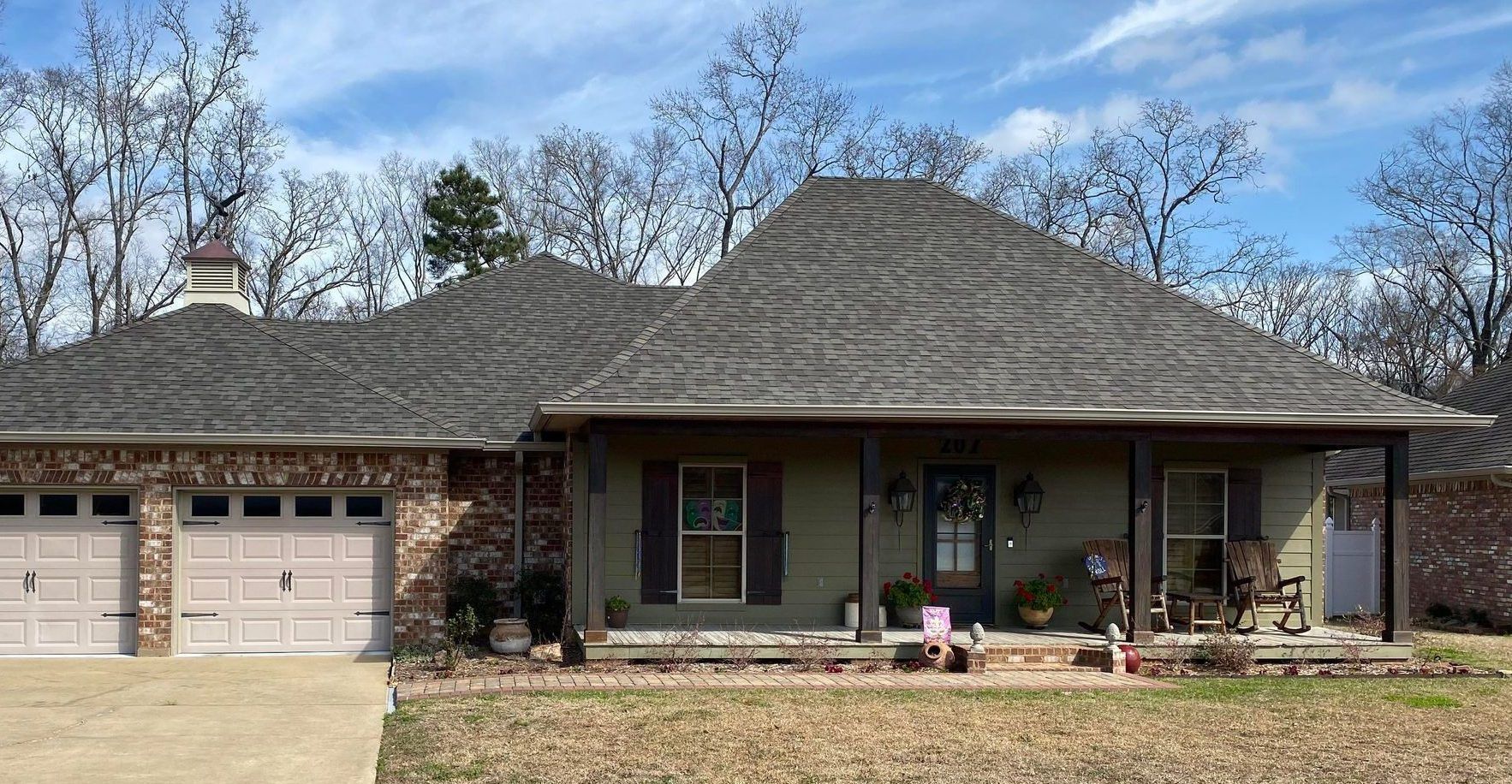 A house with a gray roof and a white garage door
