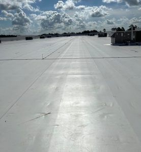 A large white roof with a blue sky in the background.