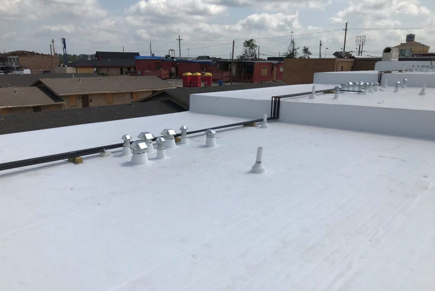 A white roof with a lot of pipes on it
