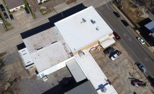 An aerial view of a building with a white roof.
