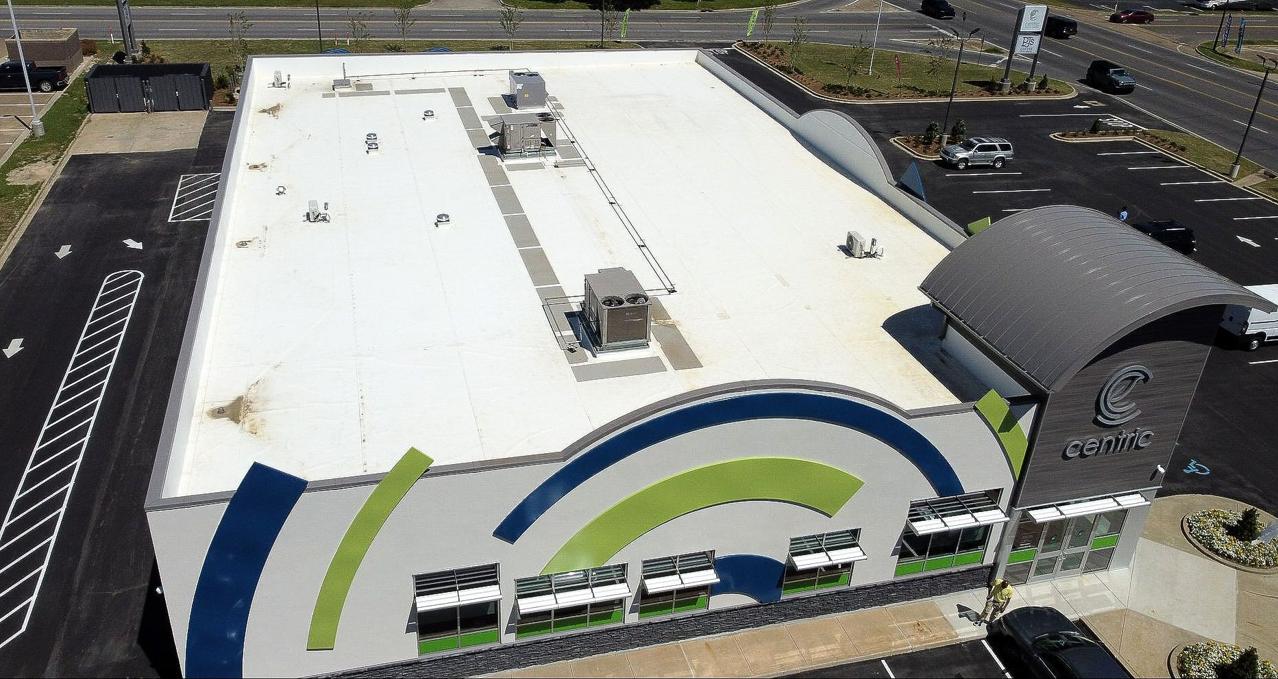 An aerial view of a large building with a white roof
