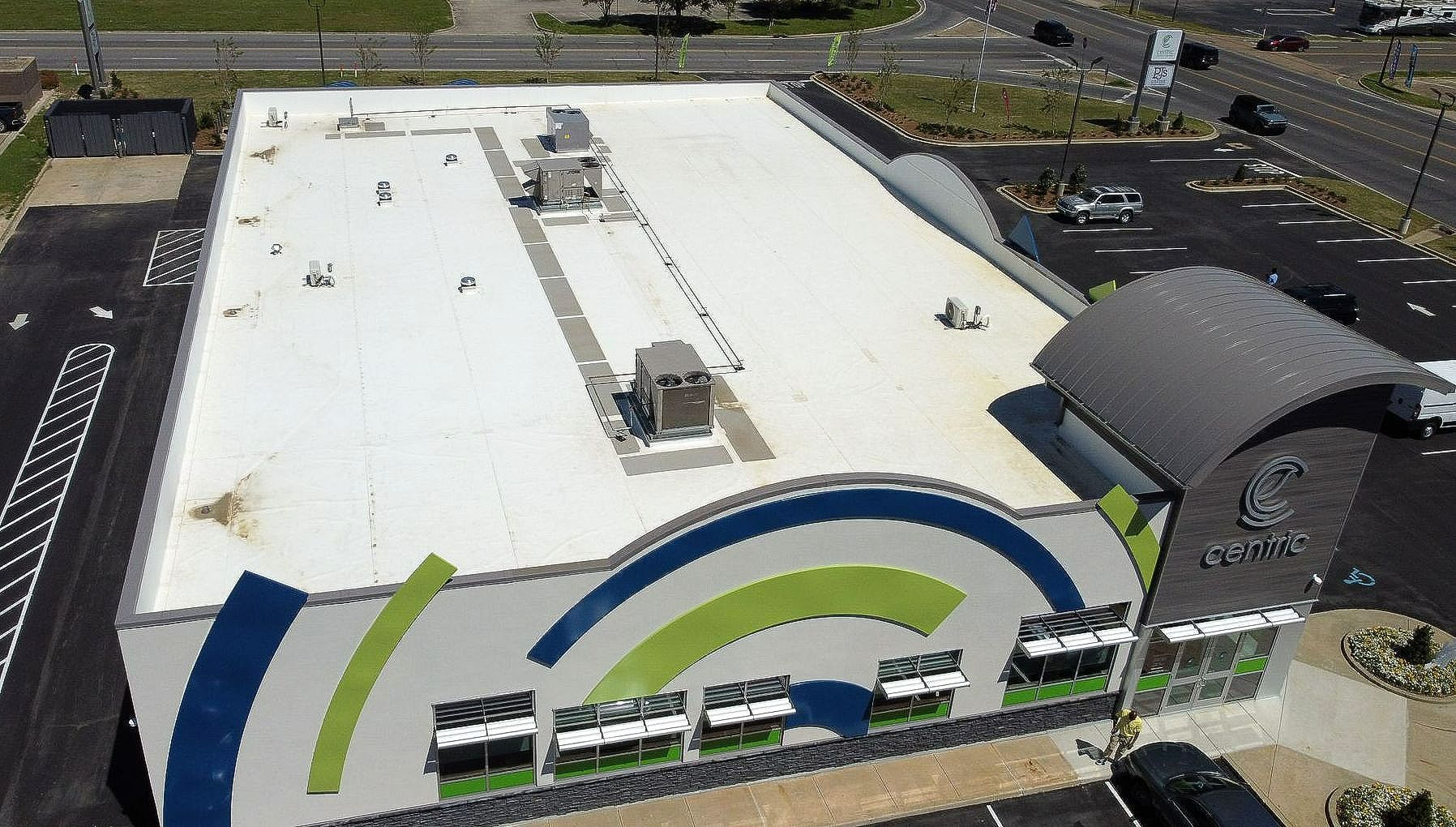 An aerial view of a large building with a white roof