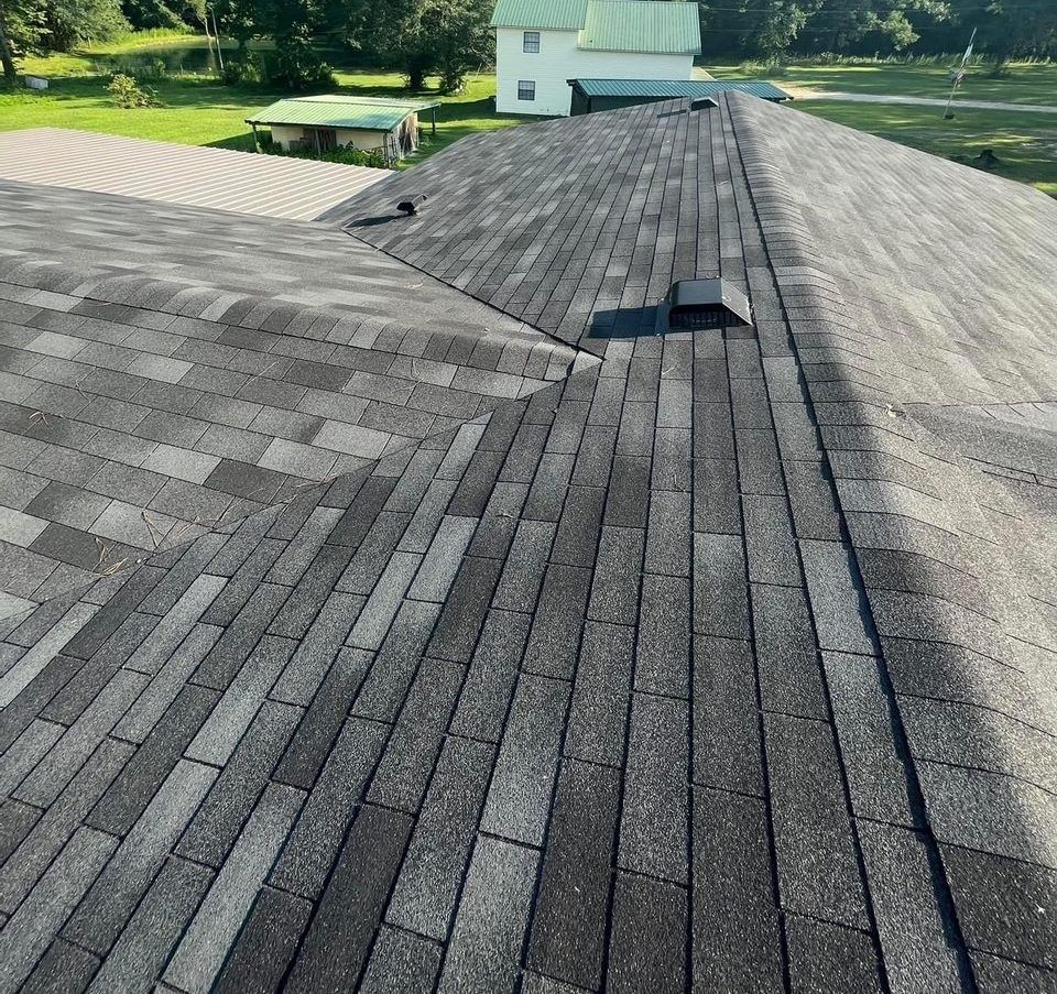 A close up of a roof with a house in the background