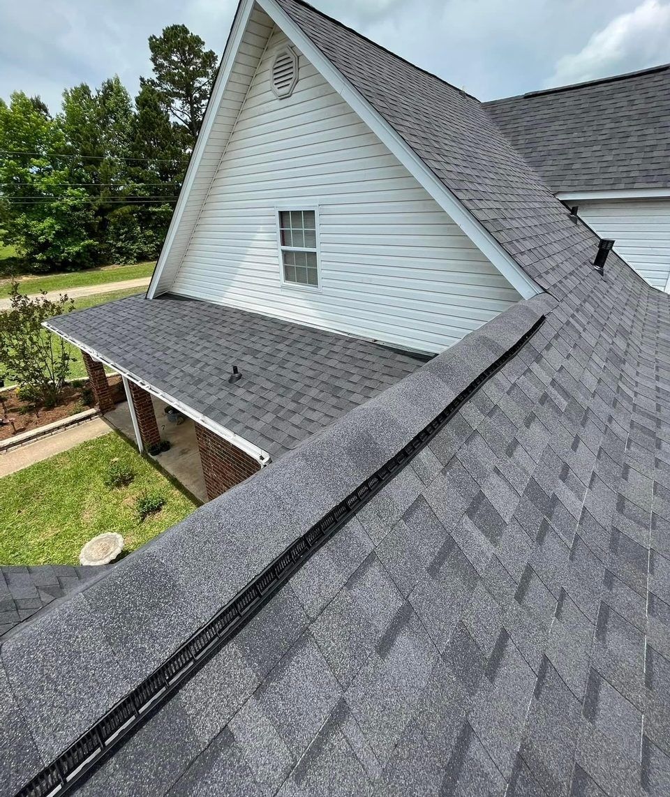 A white house with a gray roof and a porch.