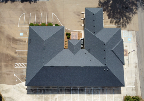 An aerial view of a building with a parking lot in front of it