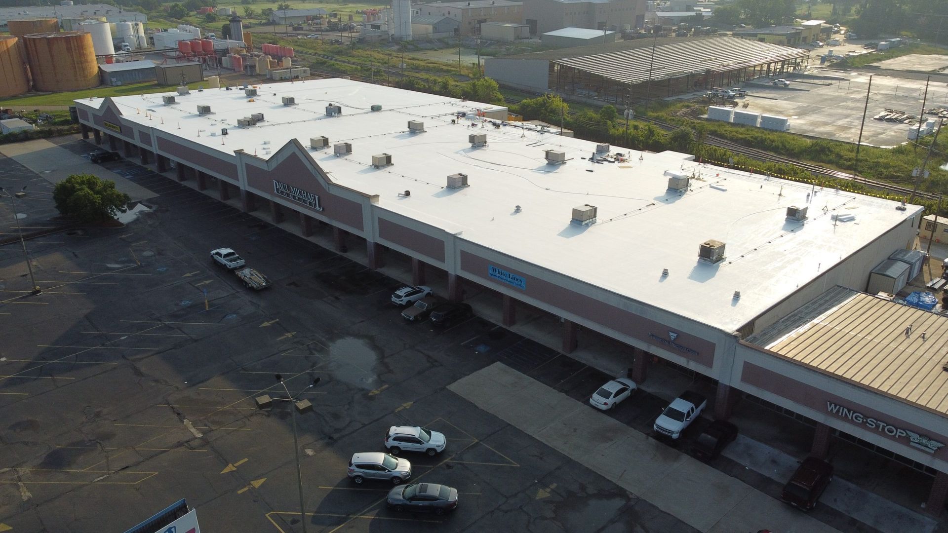 An aerial view of a large building with a white roof.