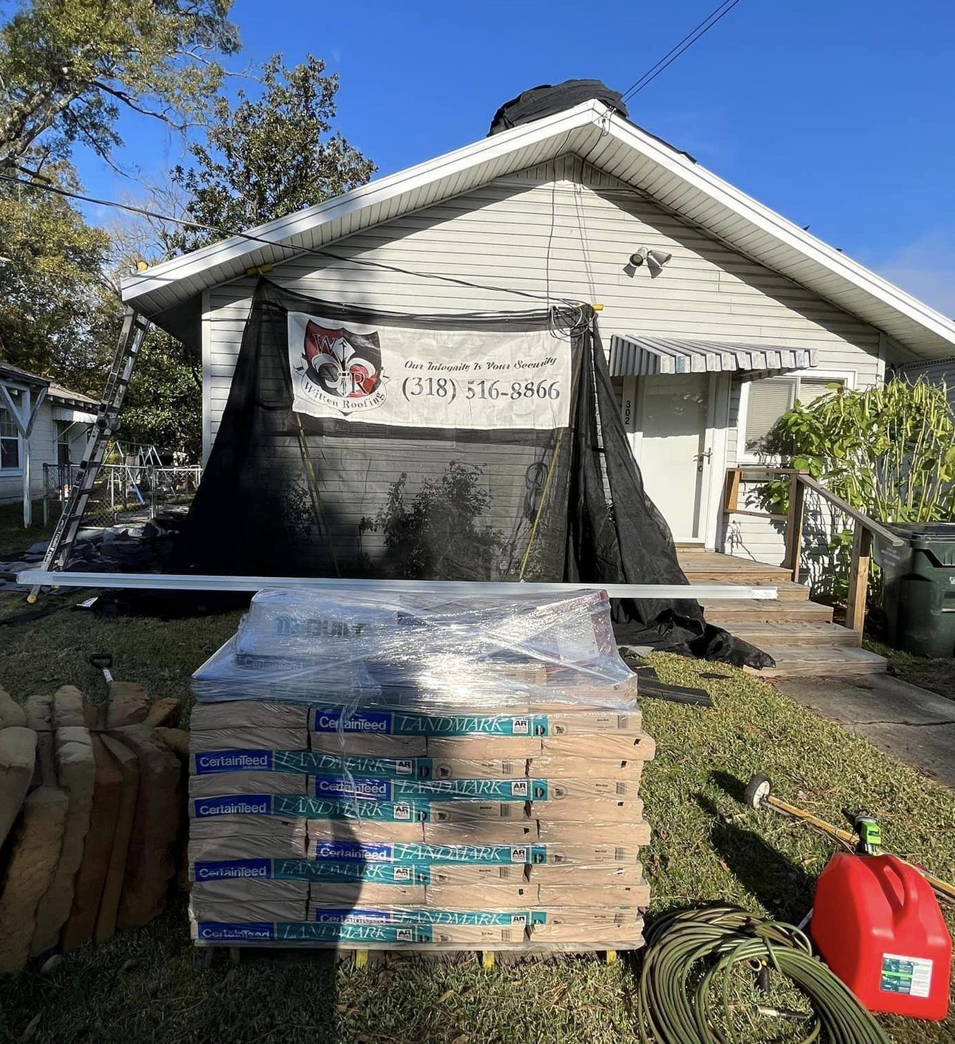 A stack of wood is sitting in front of a house.