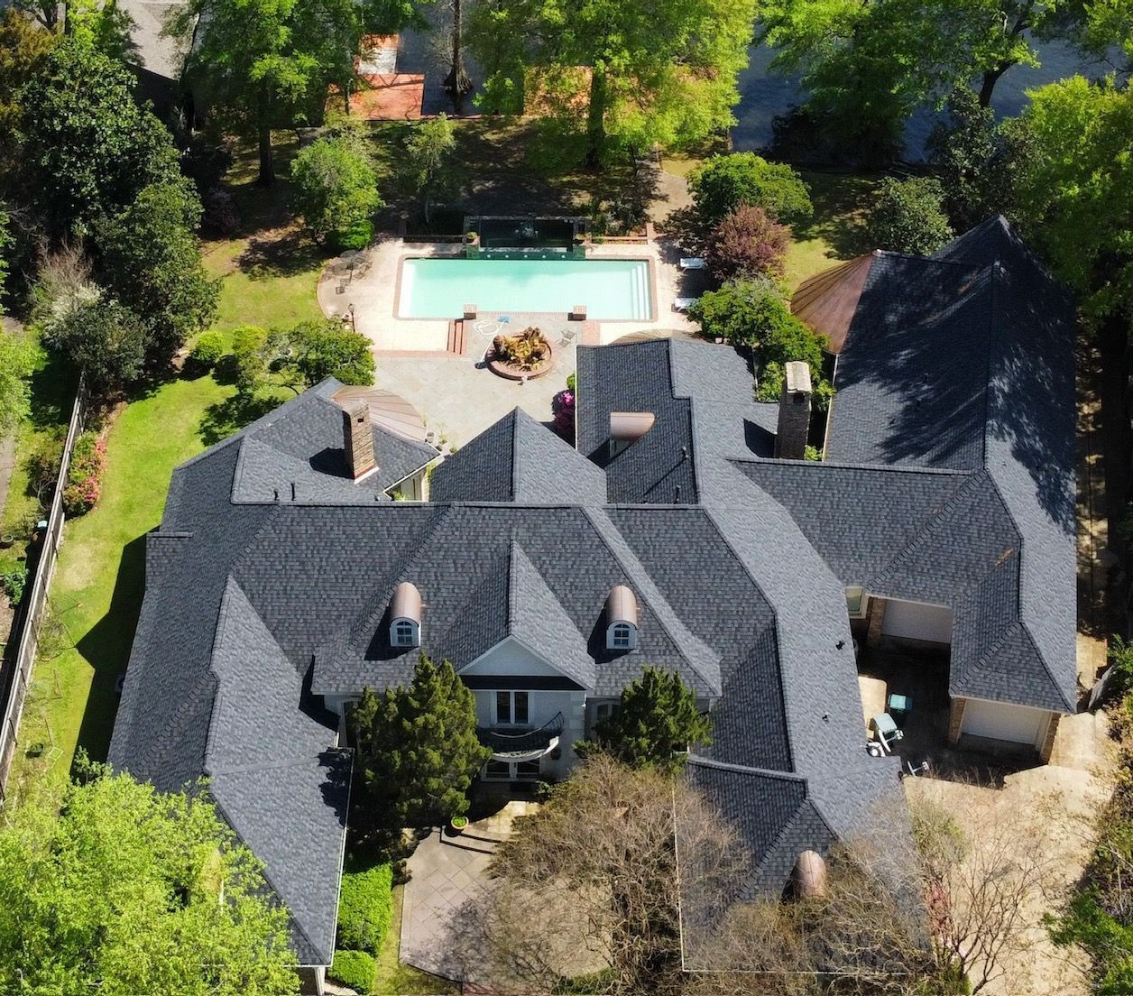 An aerial view of a large house with a pool in the backyard