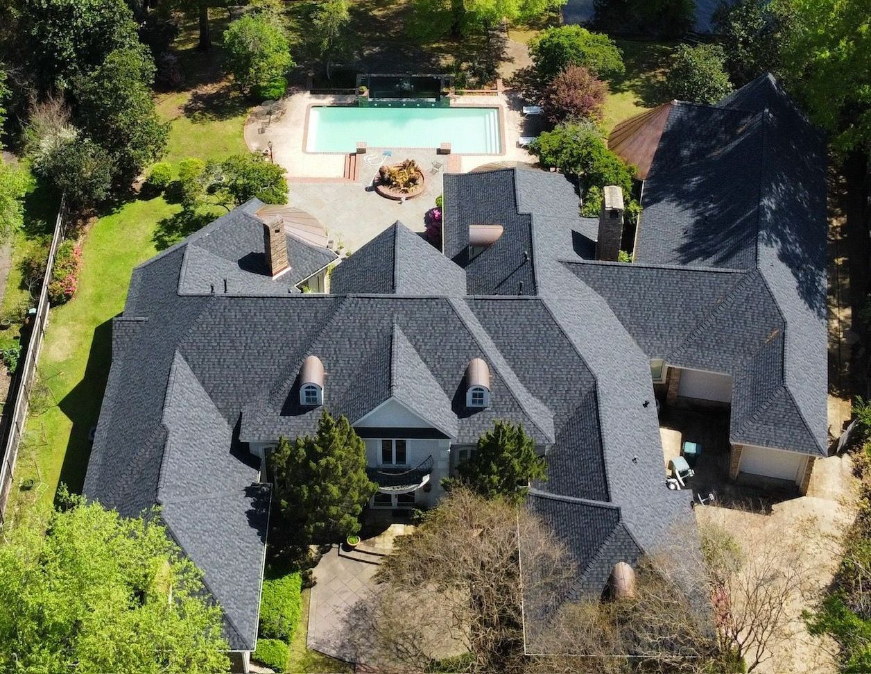 An aerial view of a large house with a pool in the backyard